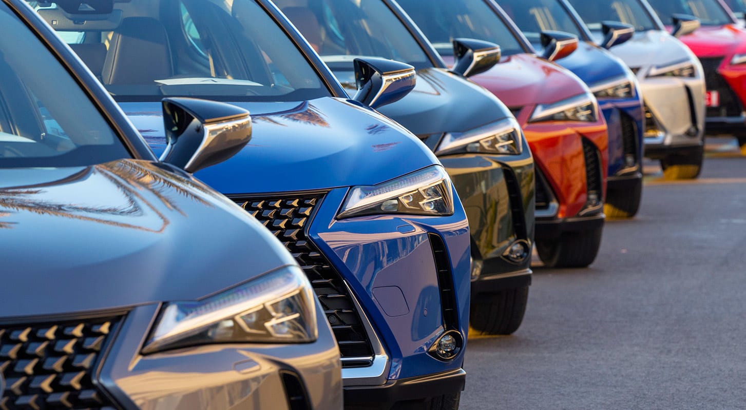 A lineup of cars in a parking lot.
